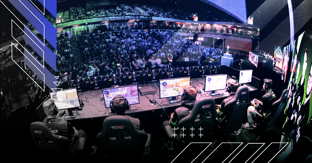 Esports arena with five gamers all playing and looking at their screens whilst an audience watches on
