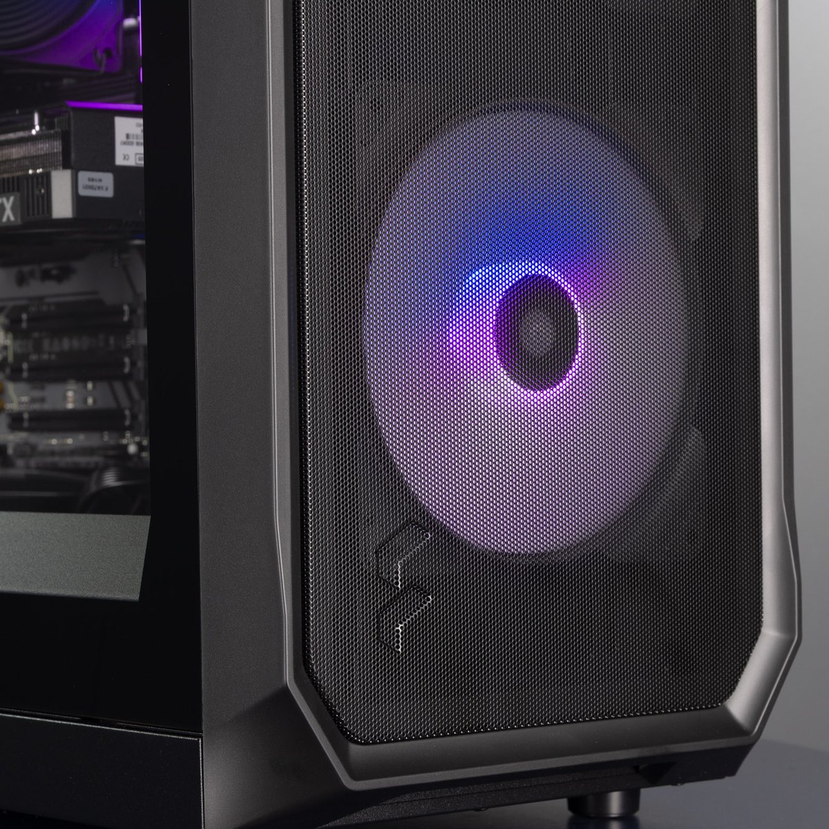 The front of the PC, showing the Fractal logo and one front fan lit up in a blue and purple gradient