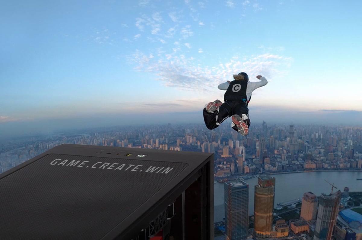Dynamic image of a skydiver leaping off a skyscraper with a Chillblast-branded backpack, set against a sprawling cityscape at sunrise, accompanied by a Chillblast PC in the foreground featuring the slogan 'Game. Create. Win.' on its top panel.