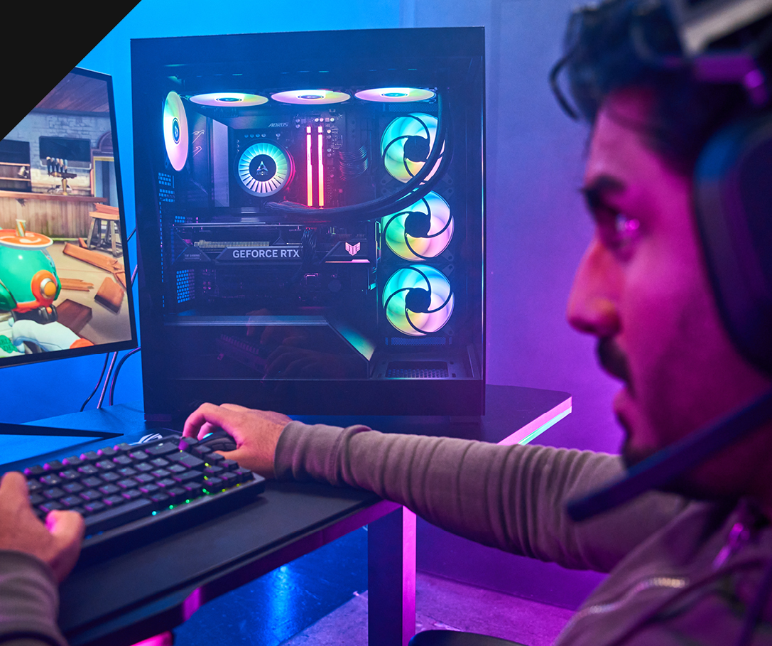 Chillblast Frontier PC with a sleek black chassis and vibrant RGB-lit cooling fans, showcased alongside a gamer wearing a headset and playing on a dual-monitor setup, highlighting immersive gameplay in a colourful, illuminated environment.