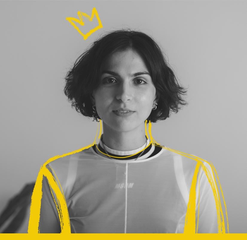 Portrait of a 3D designer with short hair, wearing a sheer top layered over a high-neck shirt, highlighted with bold yellow outlines and a crown graphic, symbolizing creativity and innovation within the Chillblast Spark Creator PC range.